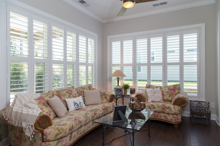 Airy sunroom with faux wood shutters in Charlotte.